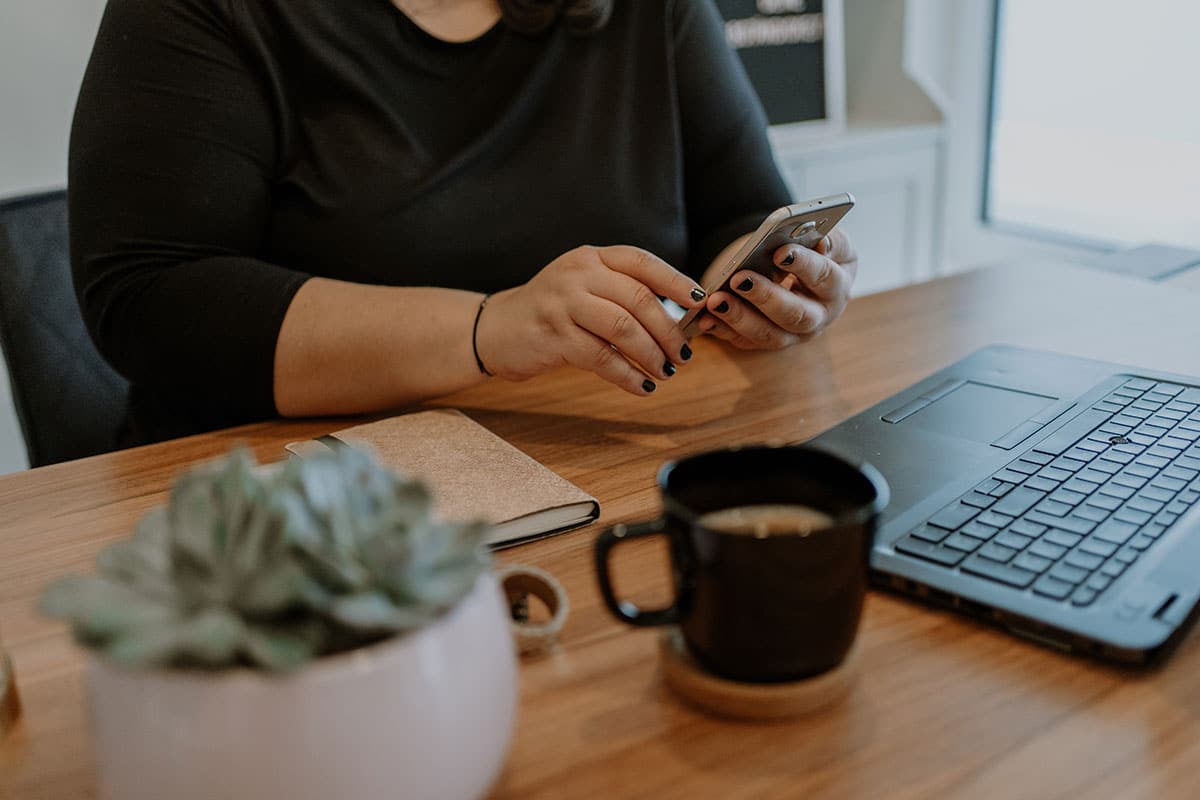 arbeitsplatz-kaffee-leptop-handy-in-der-hand